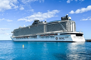 a close up image of MSC Seashore from sea level showing the calmness of the clear blue sea 