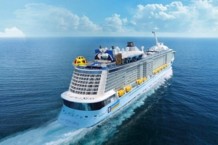 Aerial Image of the cruise ship Spectrum of the Seas sailing through the calm waters away from the camera 